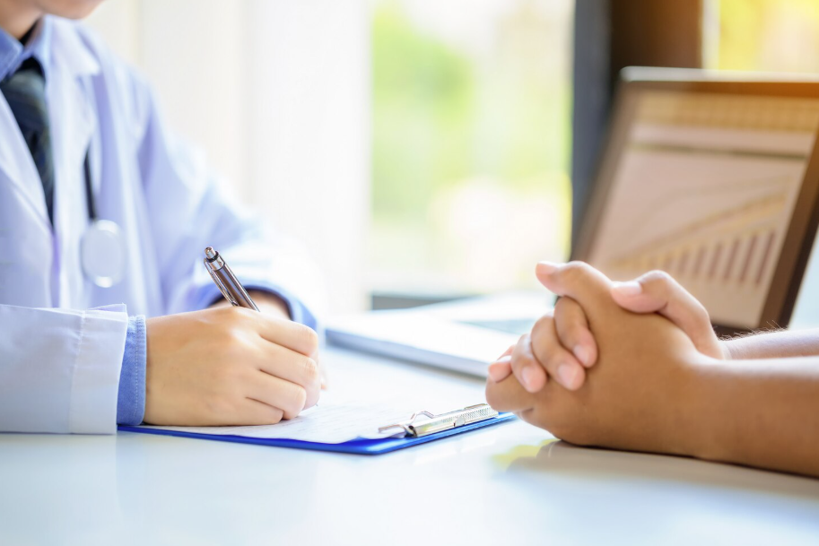 차트에 기록중인 의사와 상담중인 환자의 손