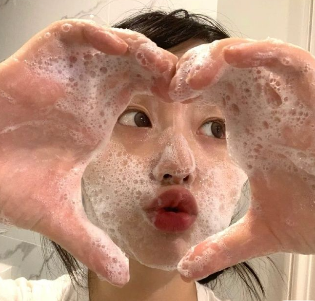 얼굴에 클렌저 거품을 묻힌 여자