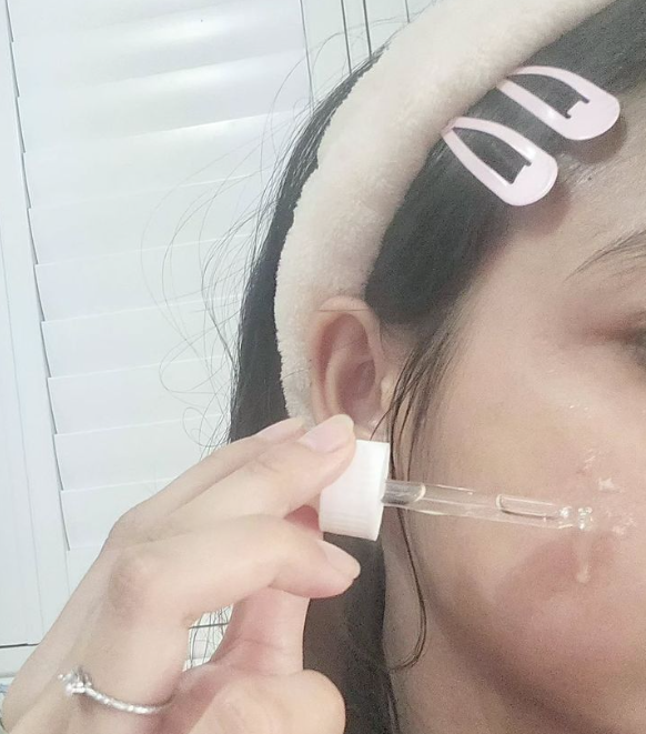 얼굴에 앰플을 바르는 여자